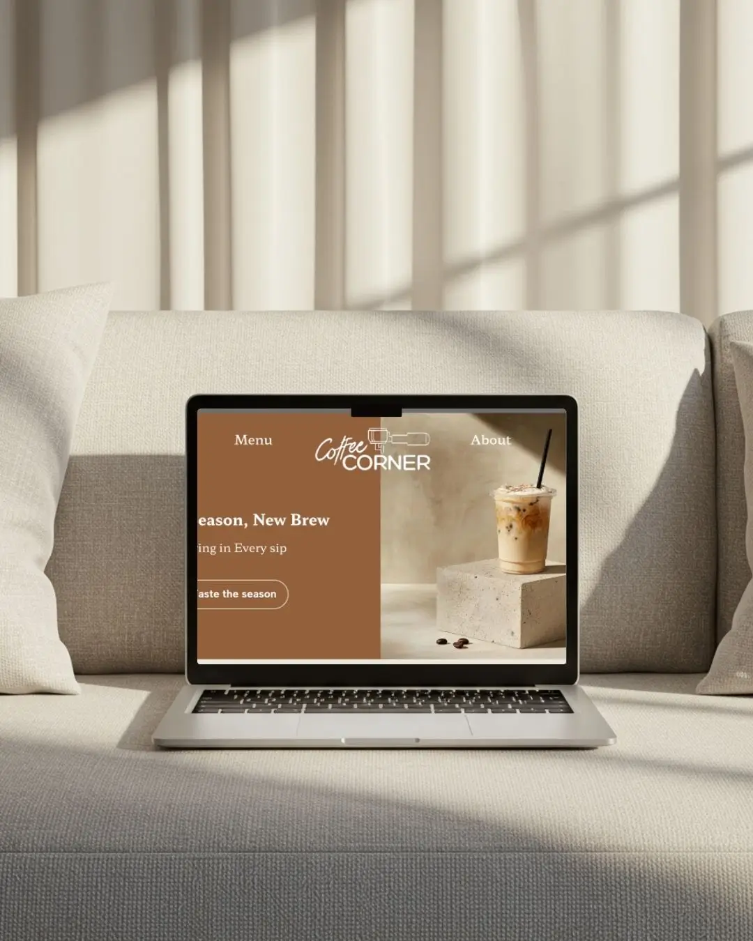 Computer der viser kaffe website, omgivet af en sofa