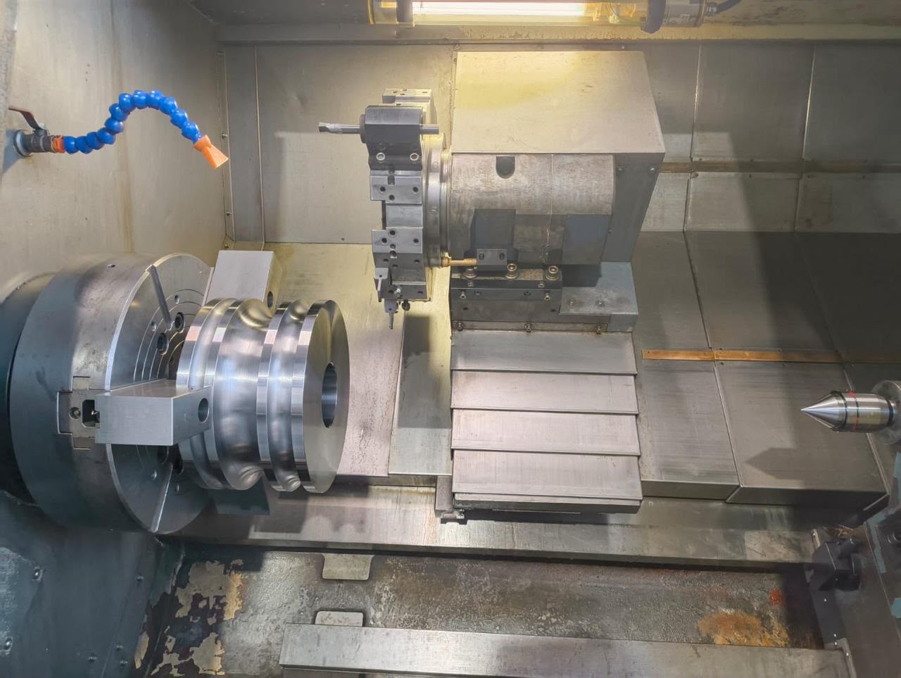 Close-up of a precision-machined circular component being turned on an industrial lathe.
