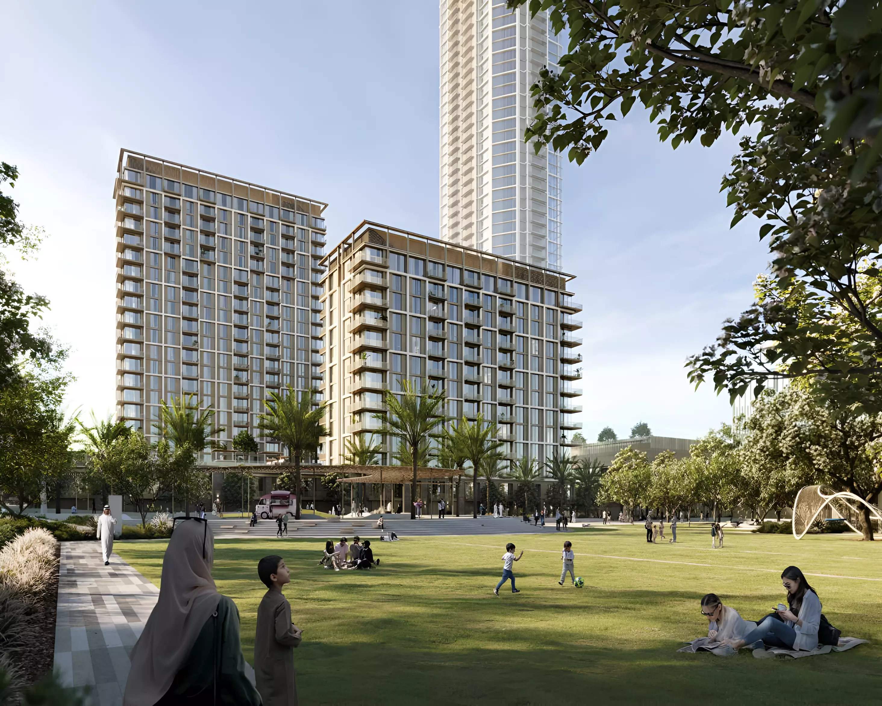 Open lawn space in Aeon Dubai with residents walking, relaxing, and children playing, surrounded by low-rise towers and lush landscaping.