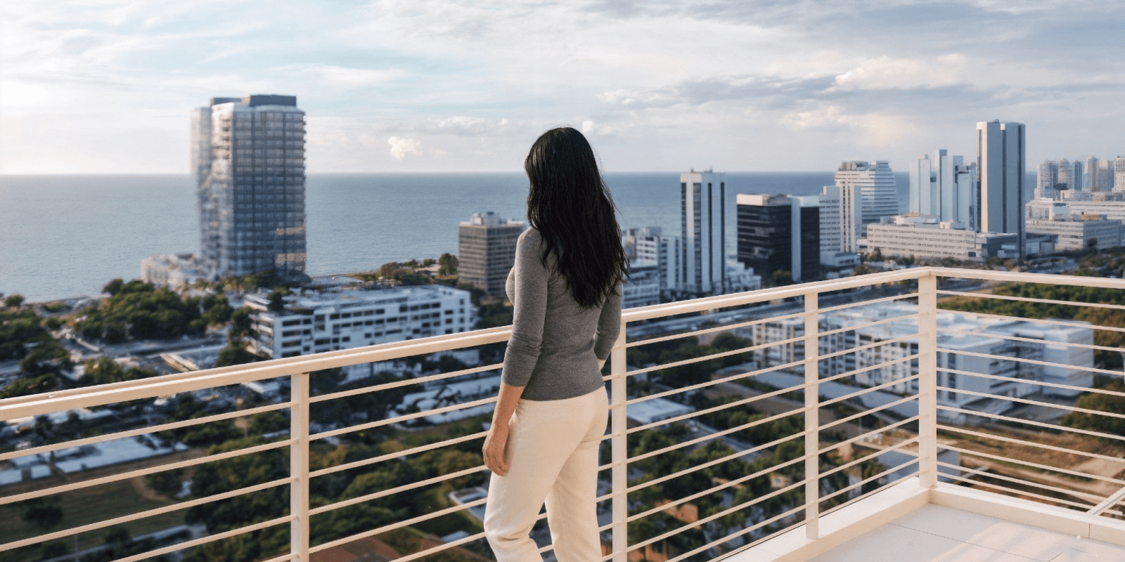 "Person enjoying the ocean view from a balcony at The Terraces, a luxury oceanfront residence in Fort Lauderdale."