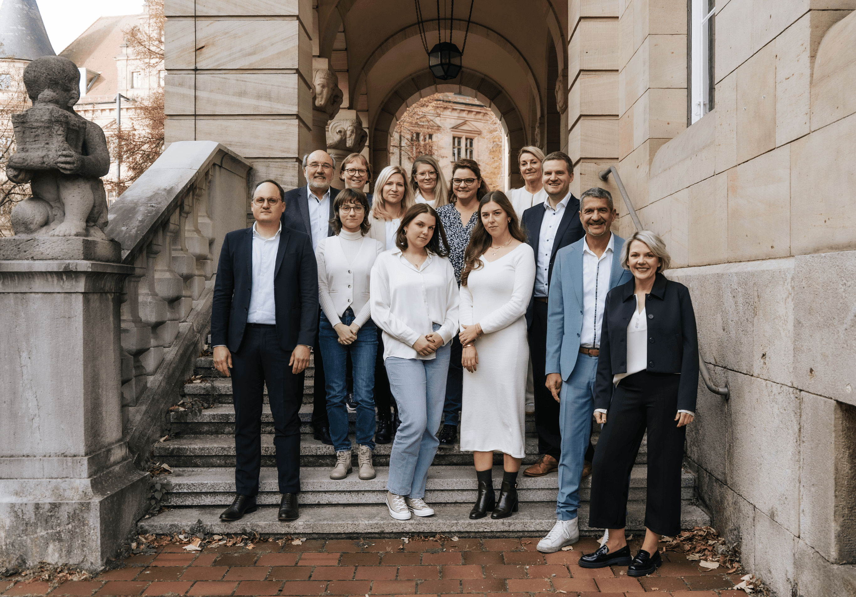 Kanzleiteam von Schick & Kollegen vor historischem Treppenaufgang in Bamberg.