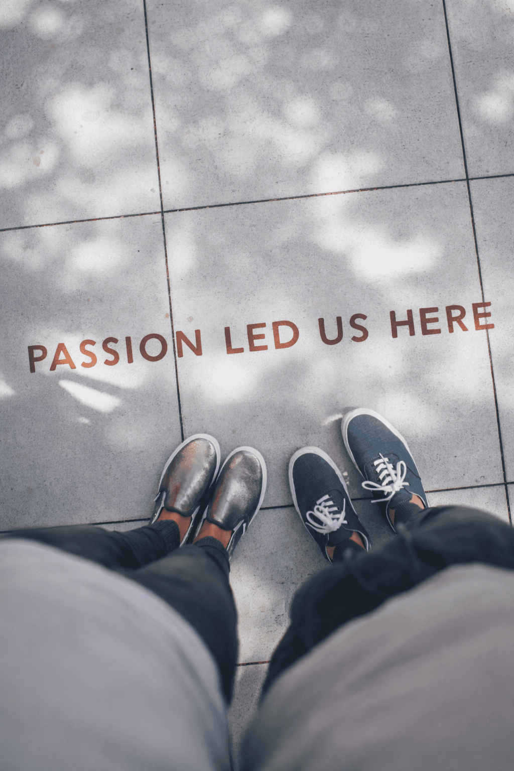 two person standing on gray tile paving