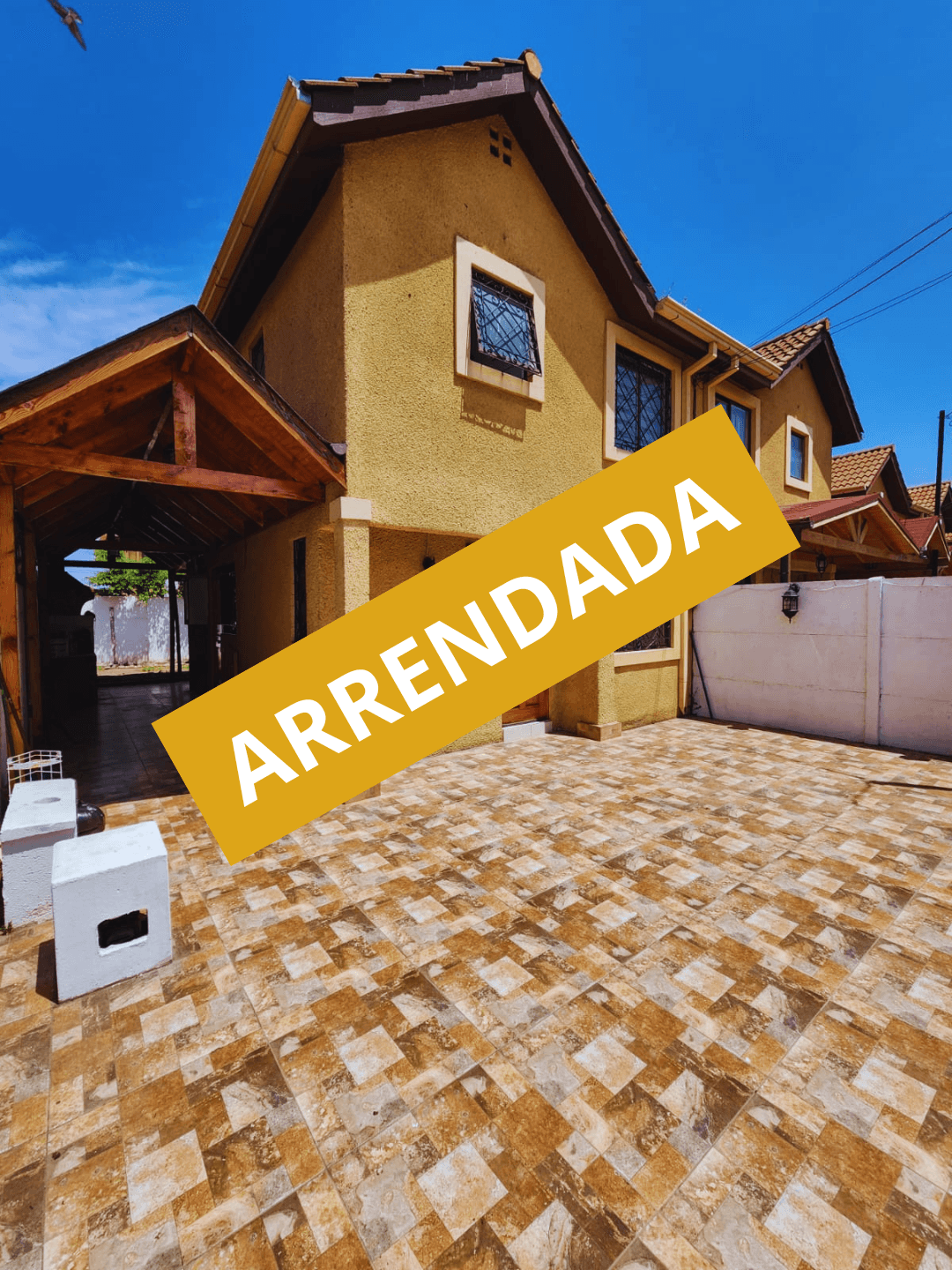 Gray modern farmhouse with ivy, a pool, and lounge chairs in a grassy area.
