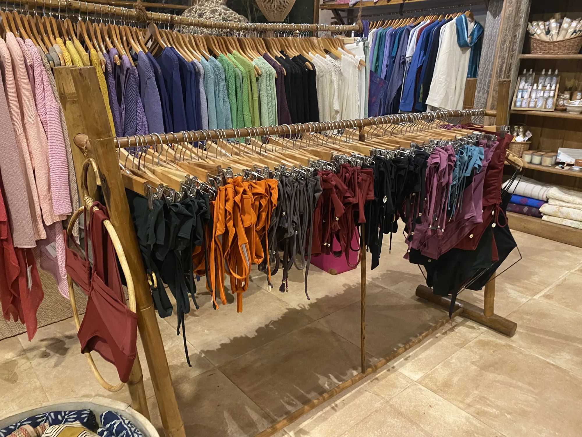 Wooden rails of pastel knitwear and colourful swimwear inside Jaali Boutique