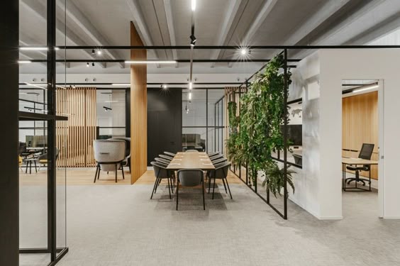 A contemporary office meeting room featuring a large wooden table, surrounded by innovative biophilic design elements and sleek glass partitions, designed by Zepspace in Bengaluru