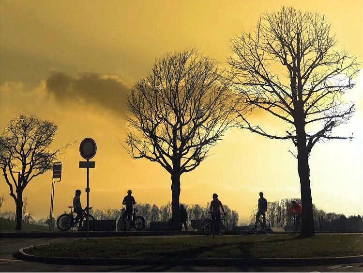 Sunset scene with four cyclists resting after a long ride