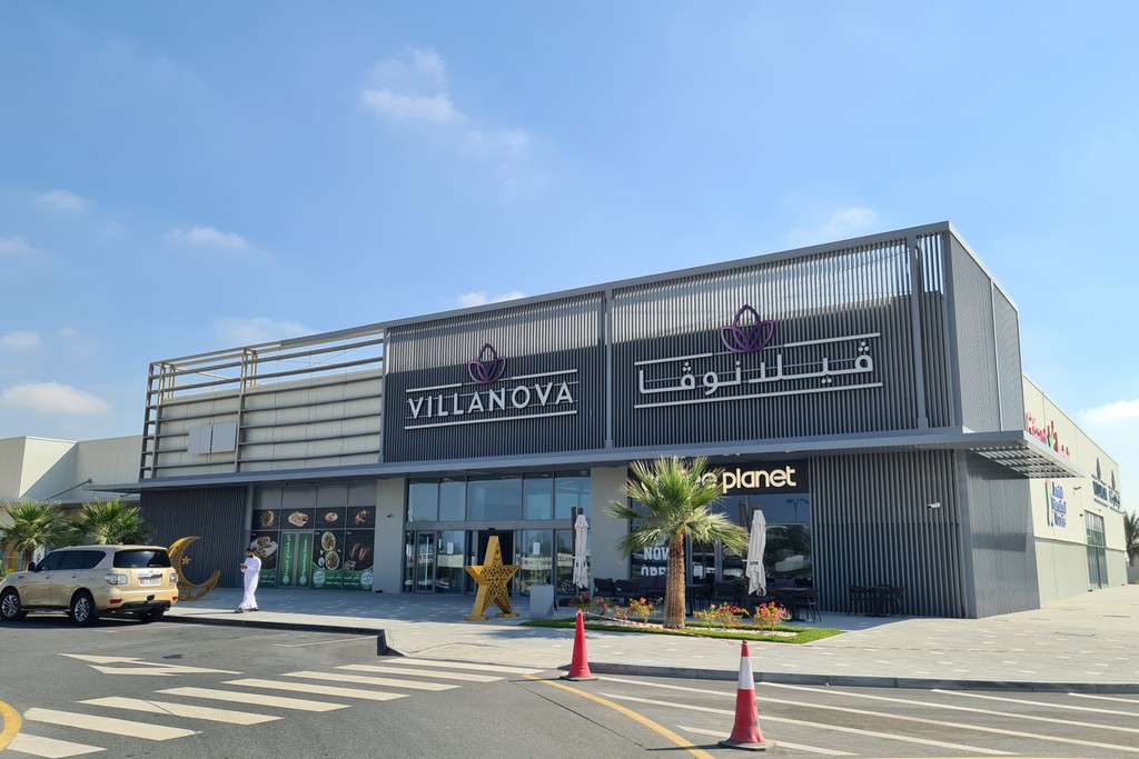 A bustling marketplace at Villanova, featuring various vendors and shoppers engaging in lively commerce.