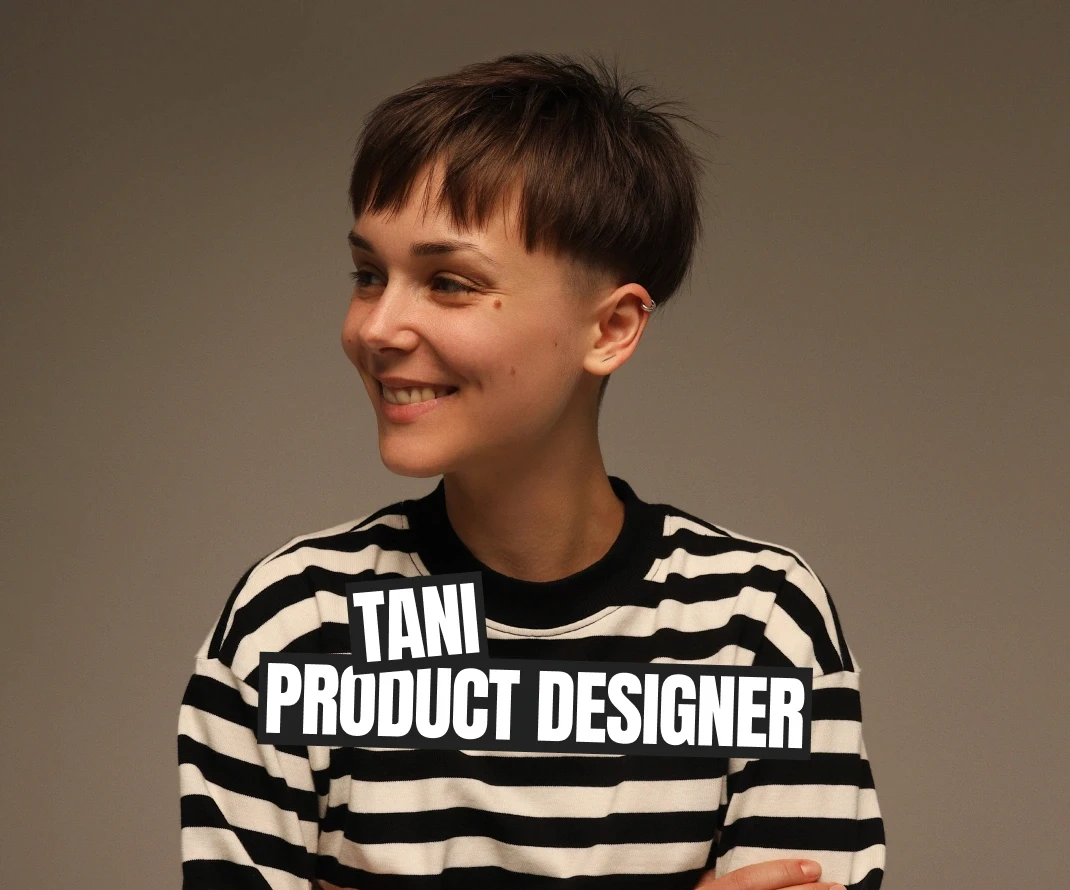 A portrait of Tani, a product designer, smiling and looking off to the side. She has short hair and is wearing a black-and-white striped shirt. Bold white text over a black background reads "TANI PRODUCT DESIGNER." The photo has a minimalistic and professional feel.