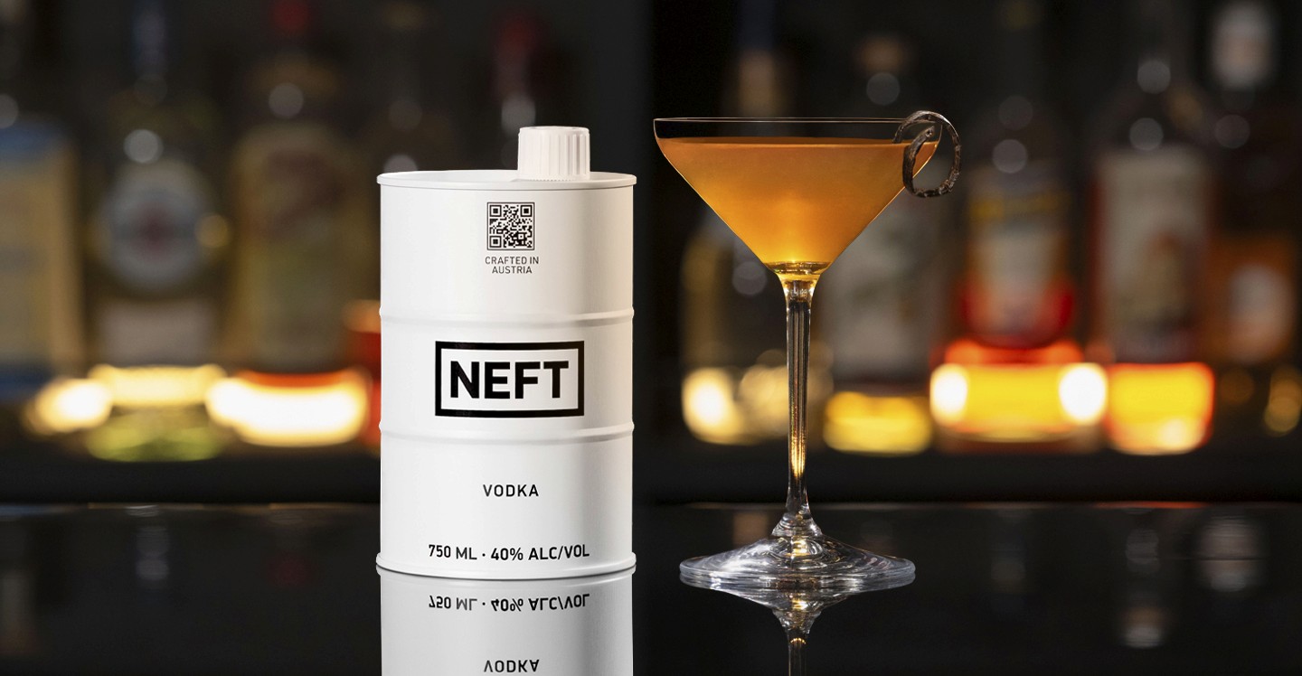 A NEFT Barrel and a glass of Pure Vanilla Martini on a bar counter.