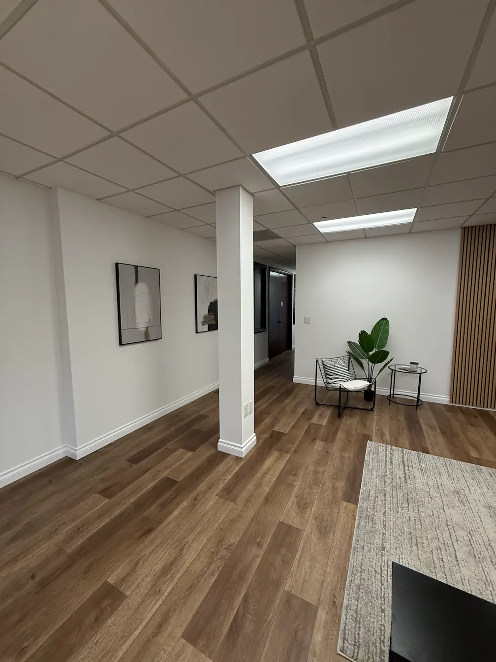 Bright open hall with workstation clusters and greenery spots