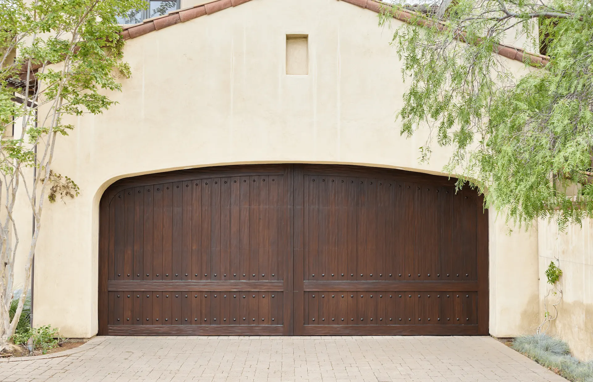 Gorgeous refinished wooden garage door in dark stain and black iron rivets from the San Juan Capistrano remodel. Photo by Todd Huge.