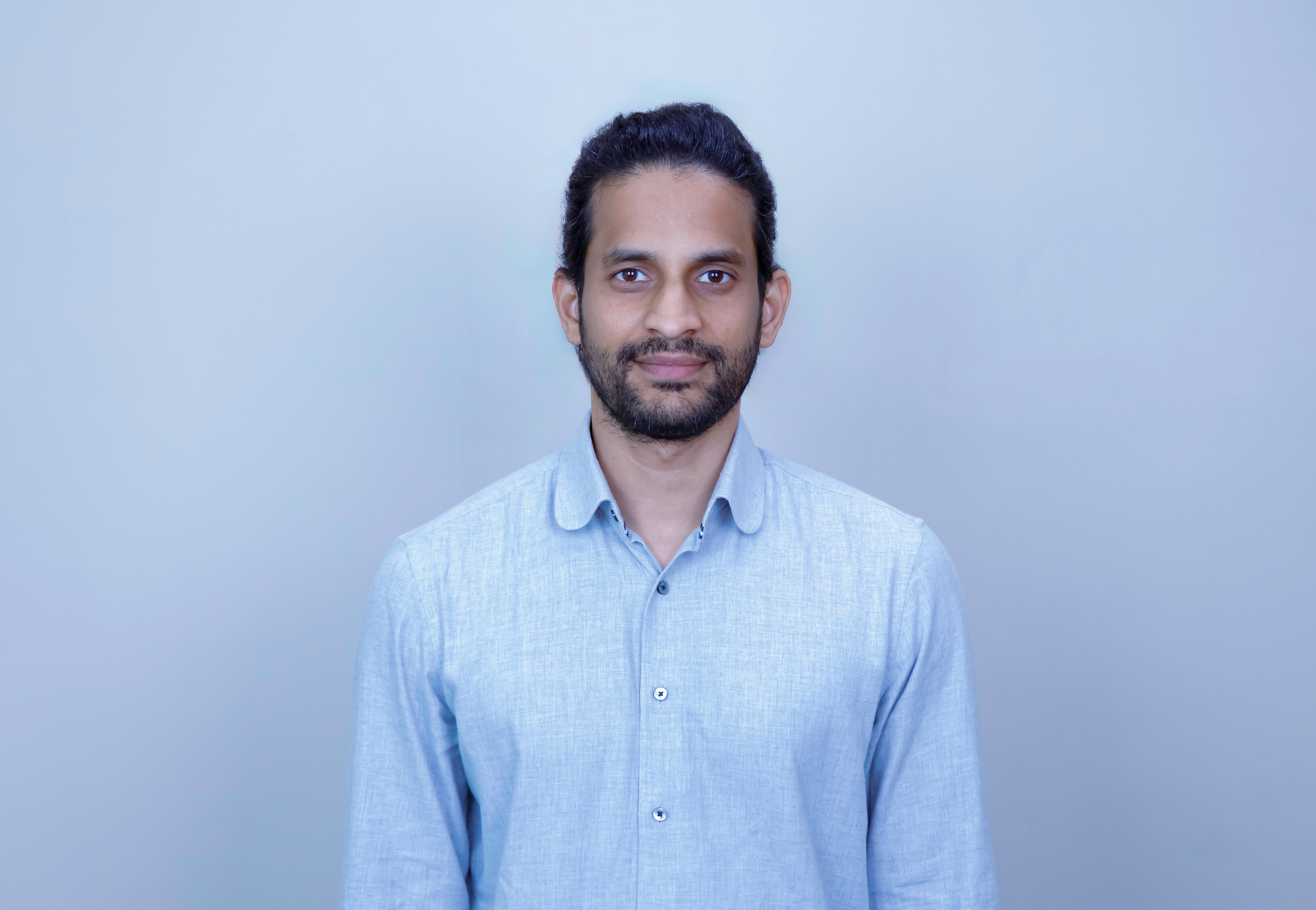 Man with arms crossed in modern office workspace.