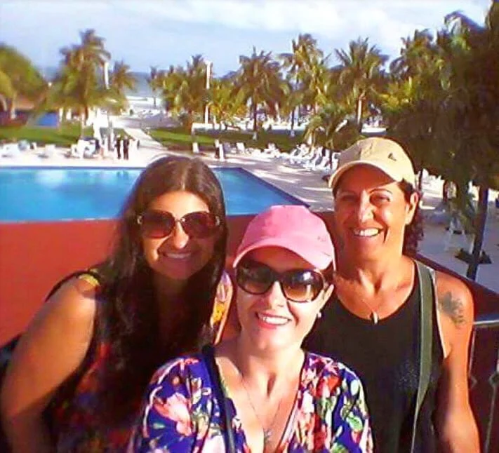 Grupo de amigas sorrindo em resort à beira-mar durante viagem