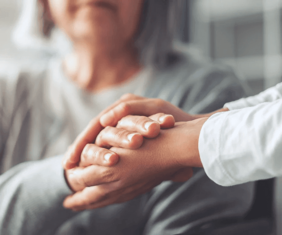Senior and nurse's hands clasped