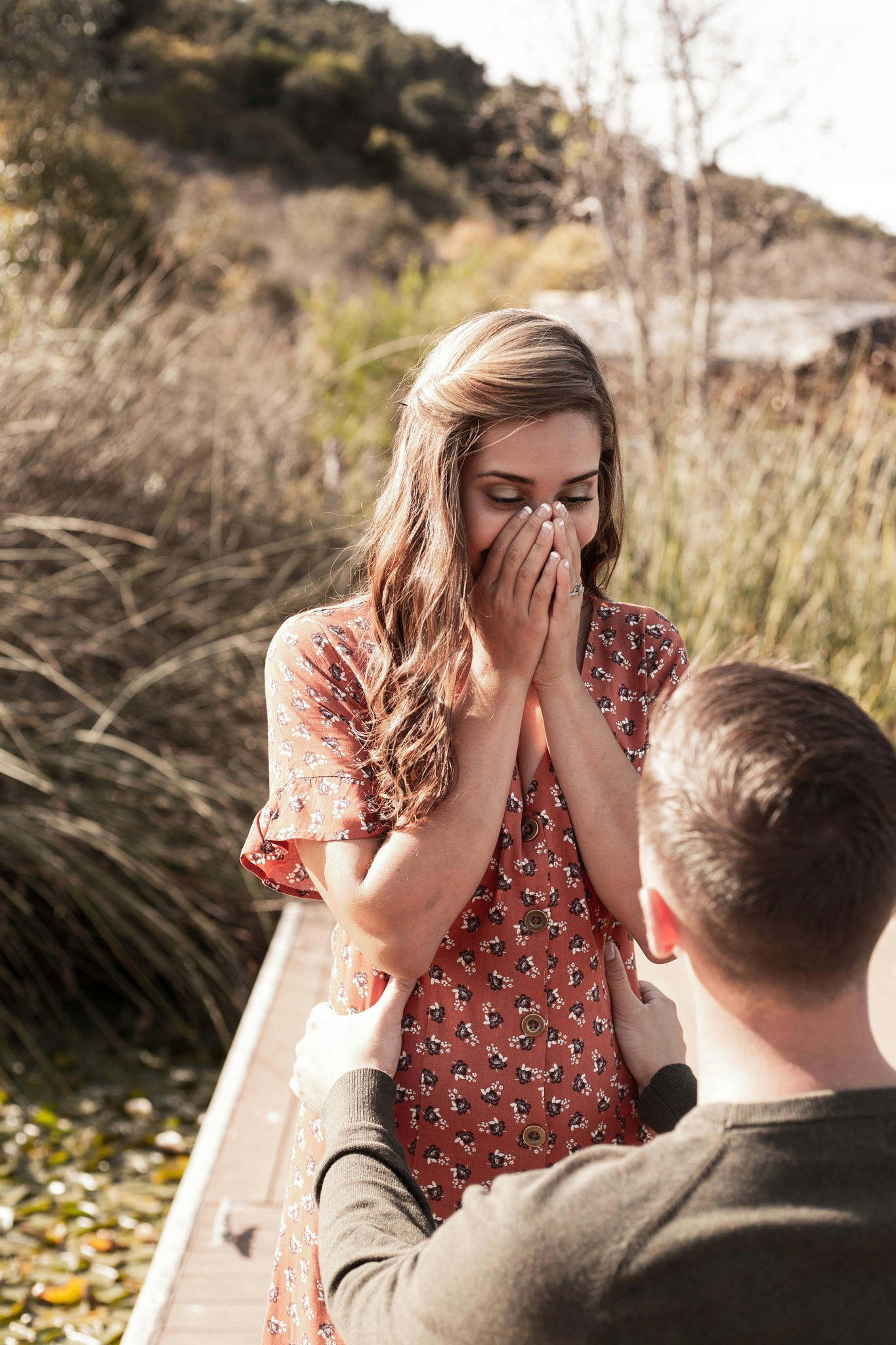 Woman smiling as her boyfriend proposes to her