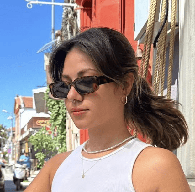 Woman with sunglasses in an outdoor setting.