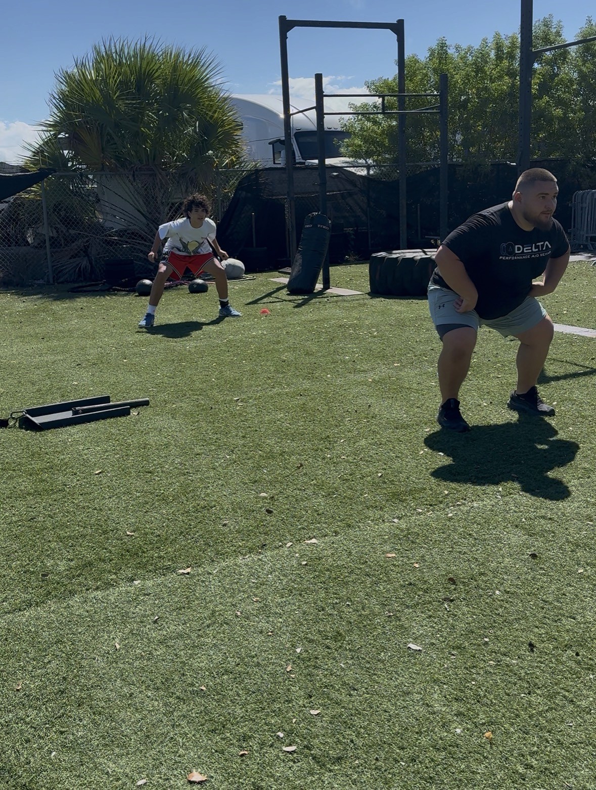 Modern sports rehab and performance training facility with turf lanes, squat racks, and open gym space—ideal for functional movement and strength rehab programs.