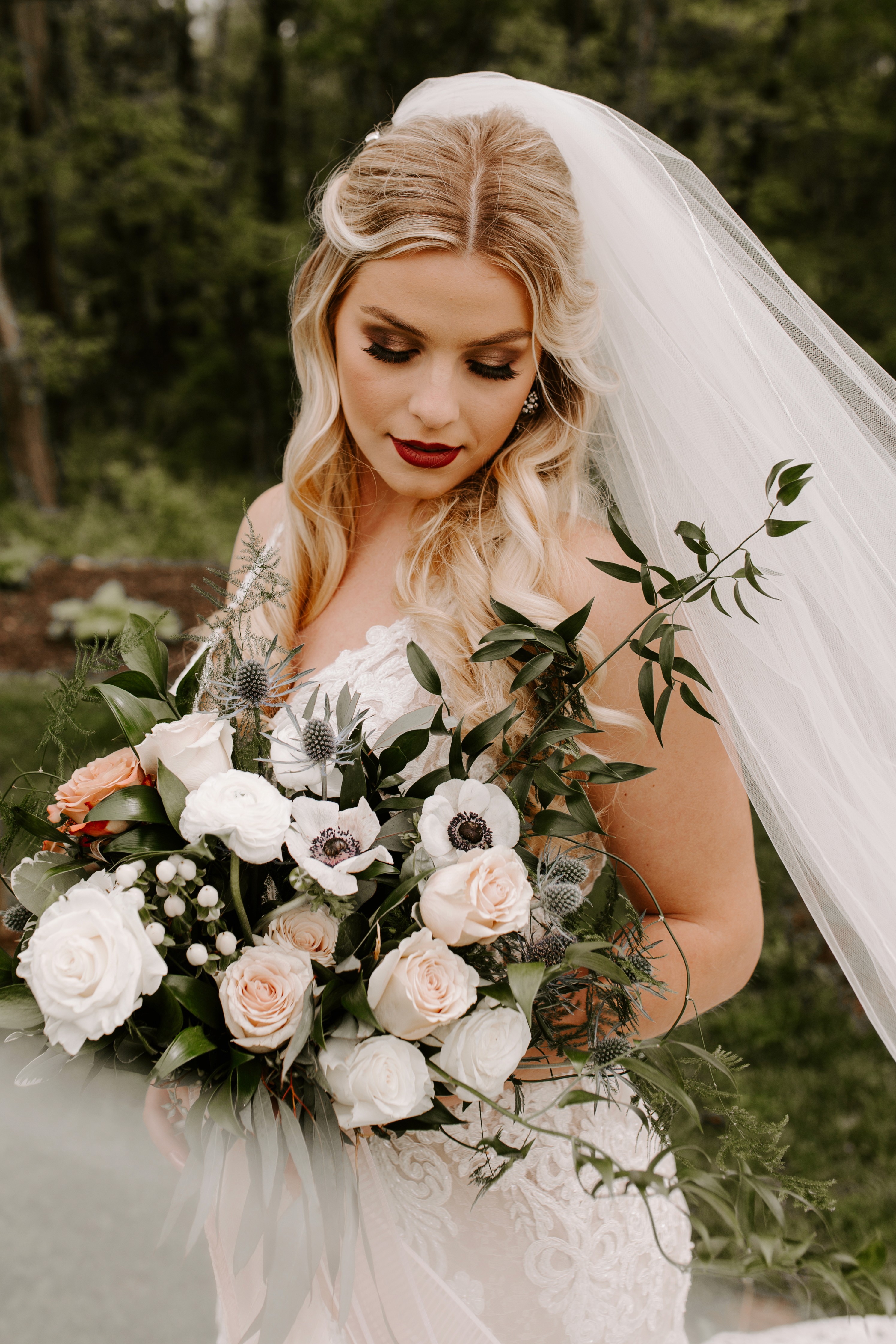 Bridal bouquet with white and blush roses and greenery in Des Moines wedding.