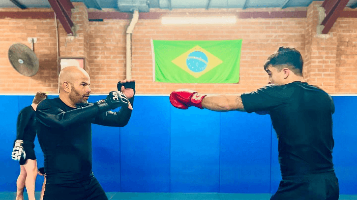 Adult students training MMA in blue mats area