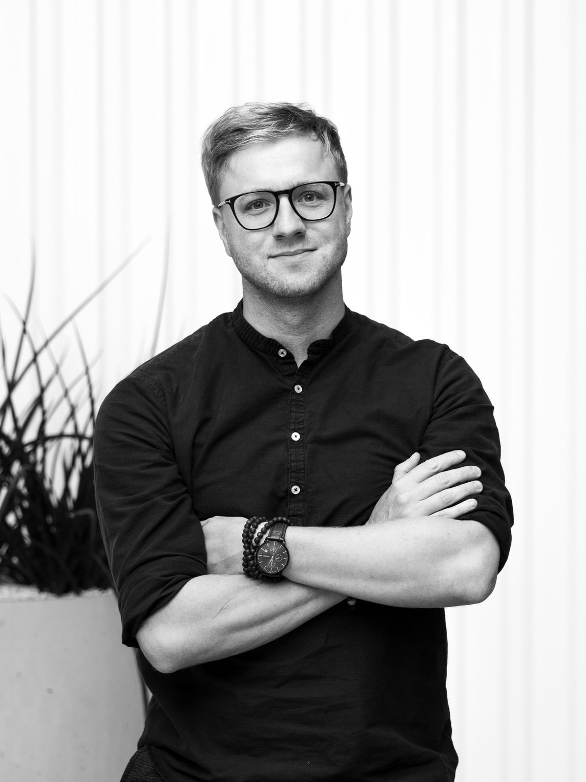 Man wearing round orange sunglasses and black jacket