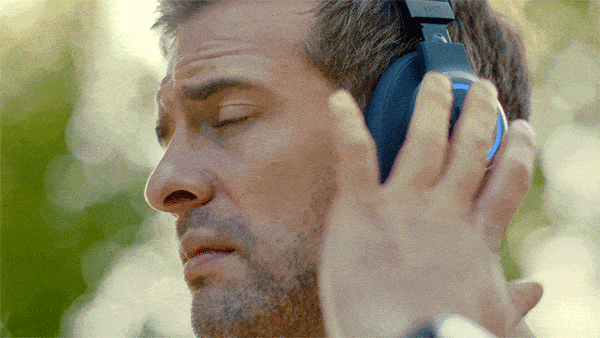 GIF showing a man pressing his headphones to talk with Siri