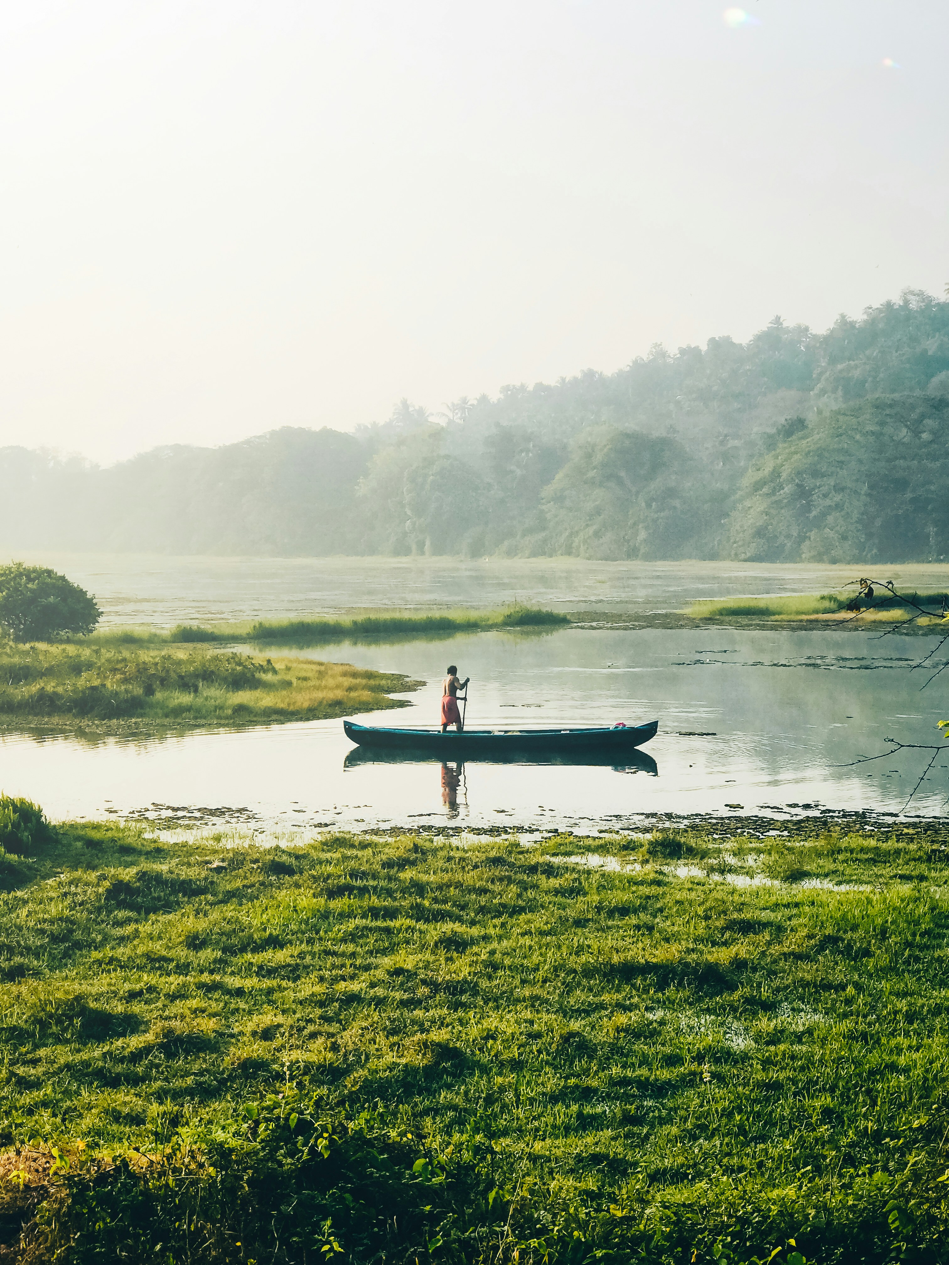a man standing in a boat on top of a lake