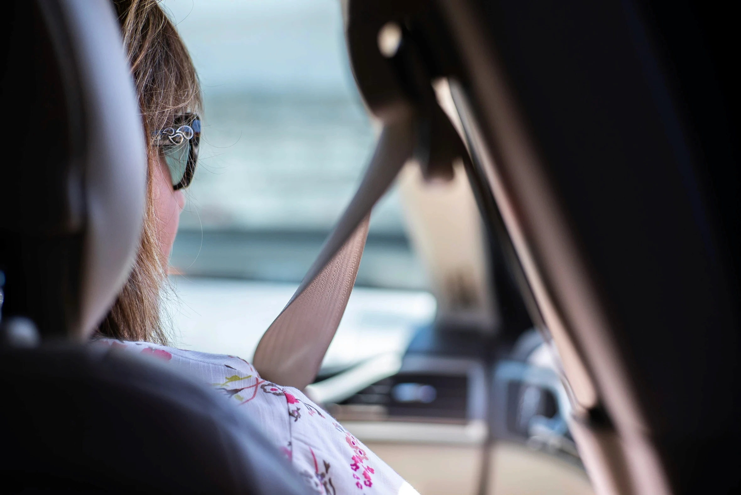a woman sitting in a car wearing a seatbelt