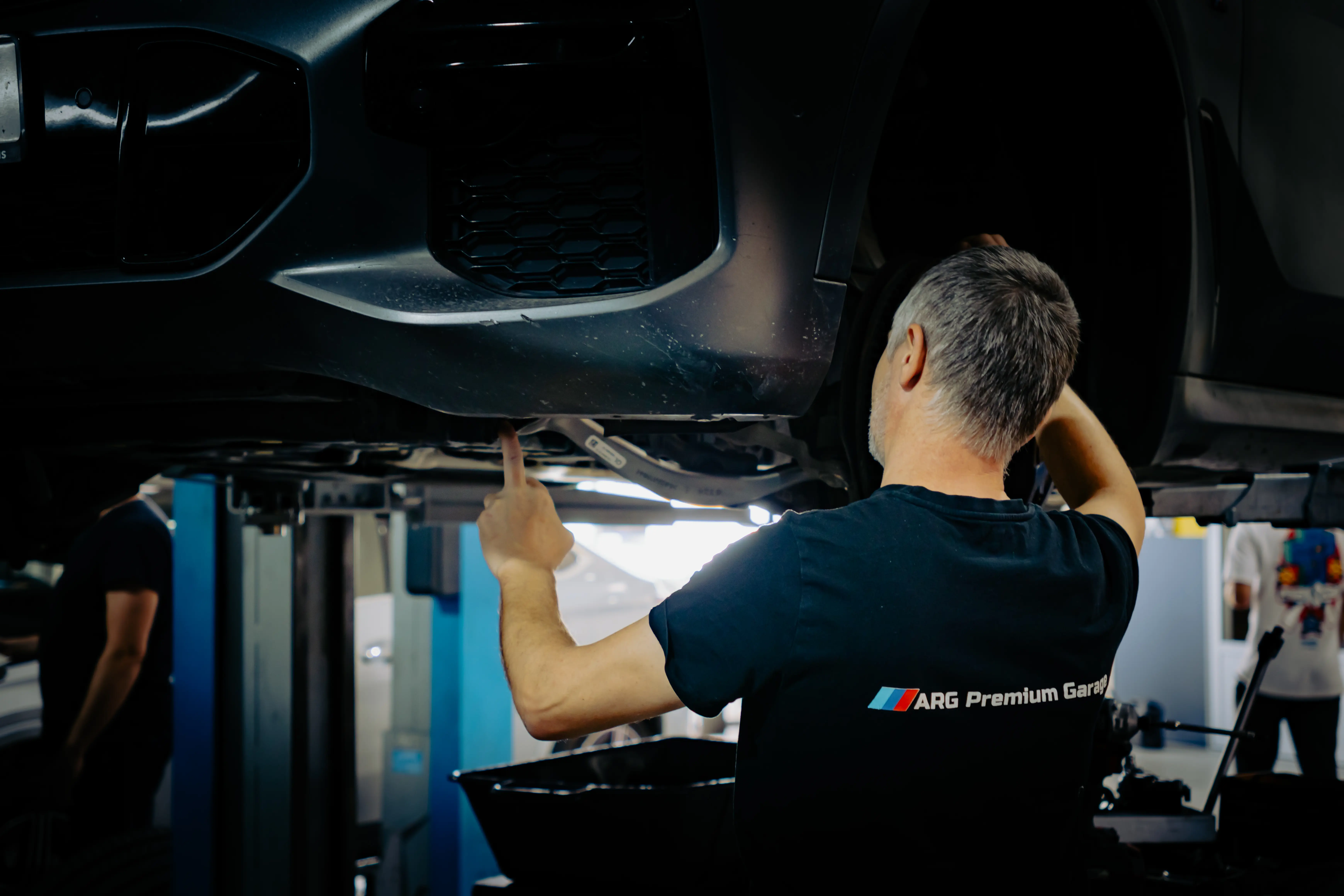 Professional technician performing vehicle undercarriage inspection