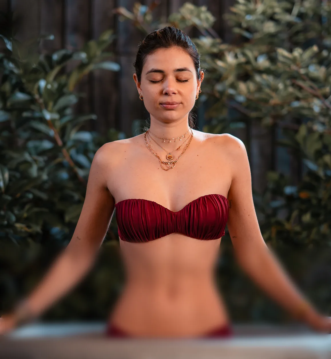 A woman with her eyes closed sitting calmly in an ice bath