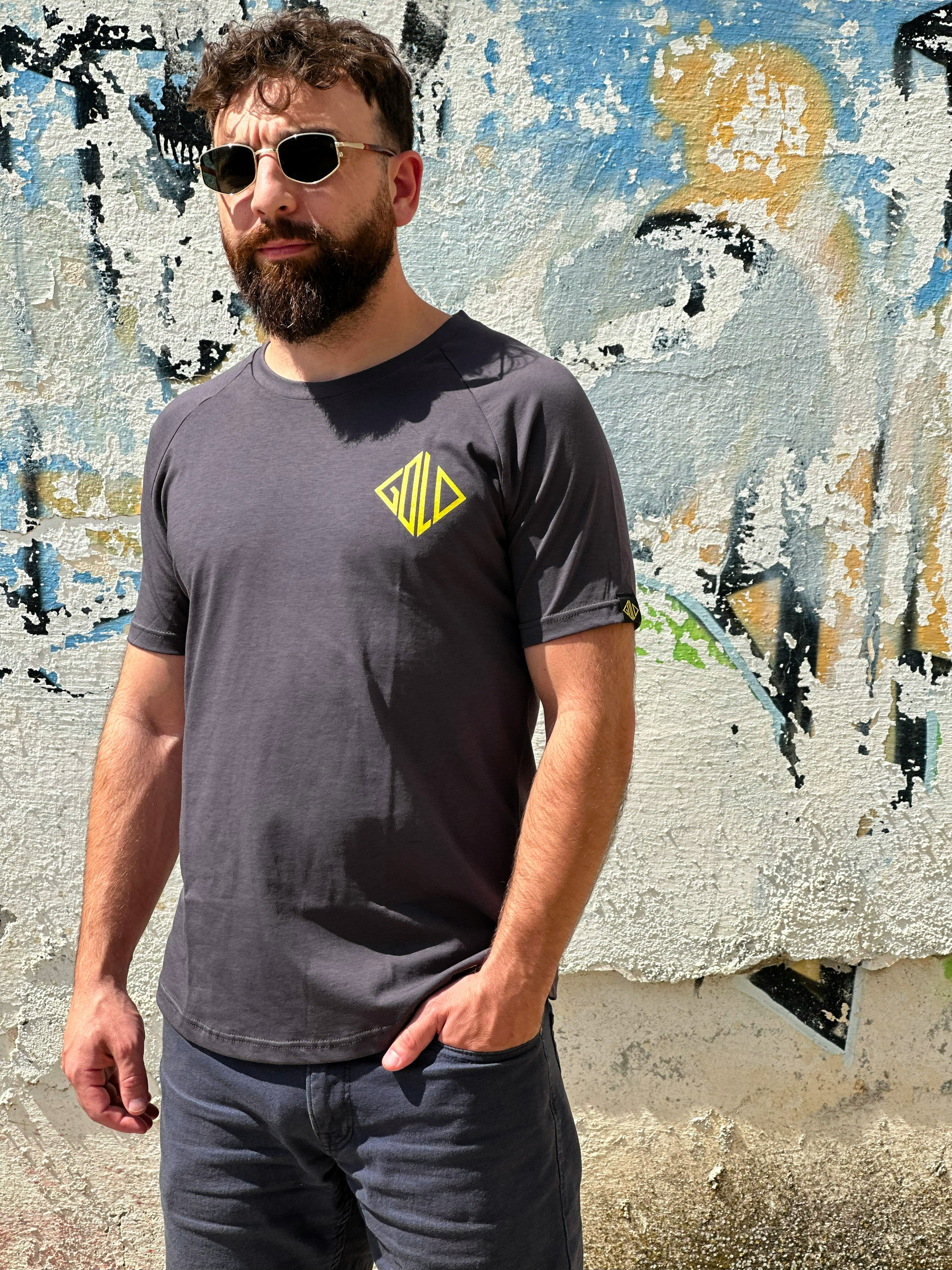 A man standing in front of a wall with graffiti