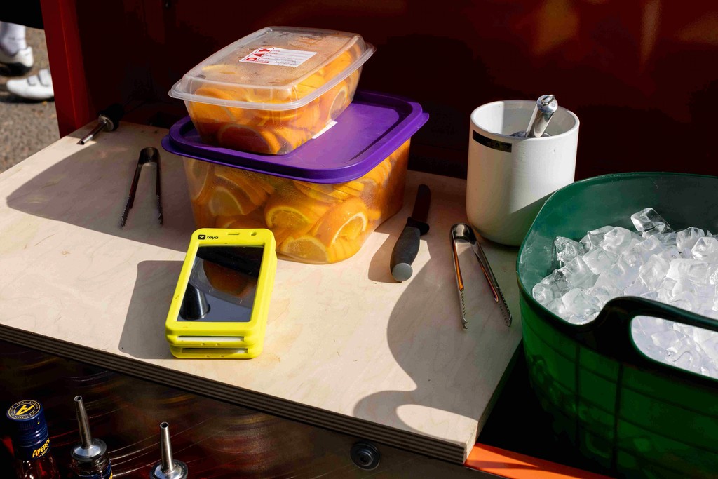 a Teya card machine on a counter with a box of oranges and an ice basket