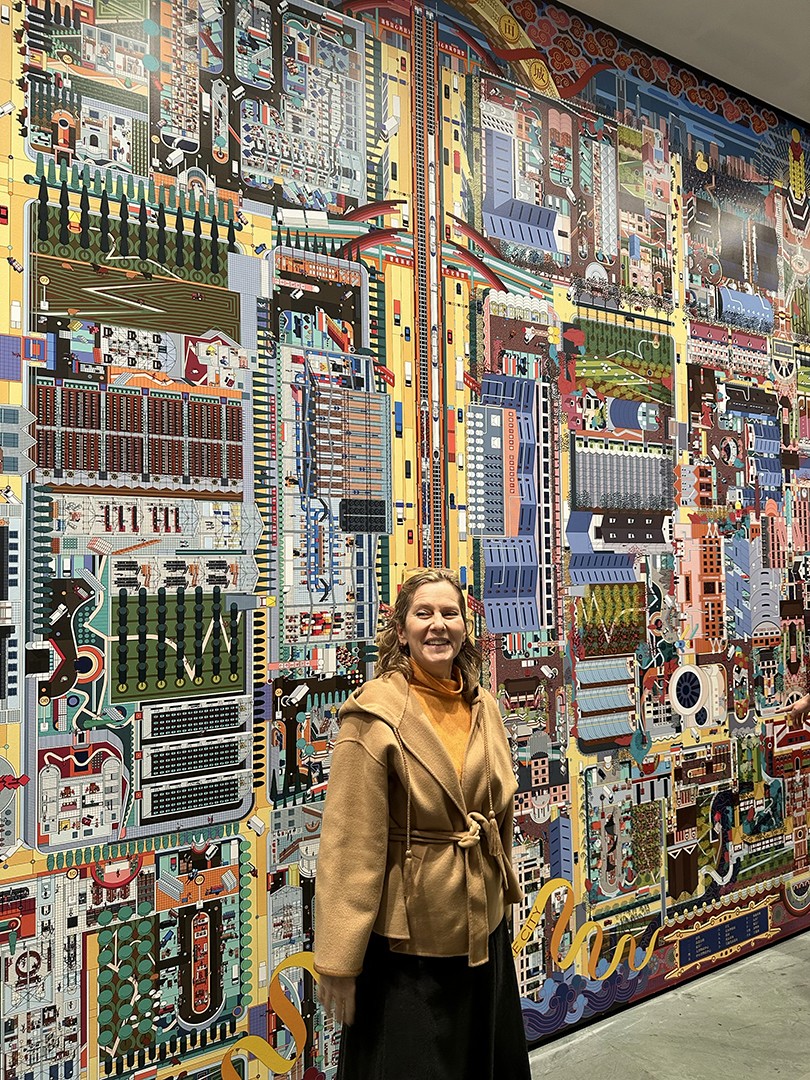 woman standing in front of an art piece explaining it to a crowd
