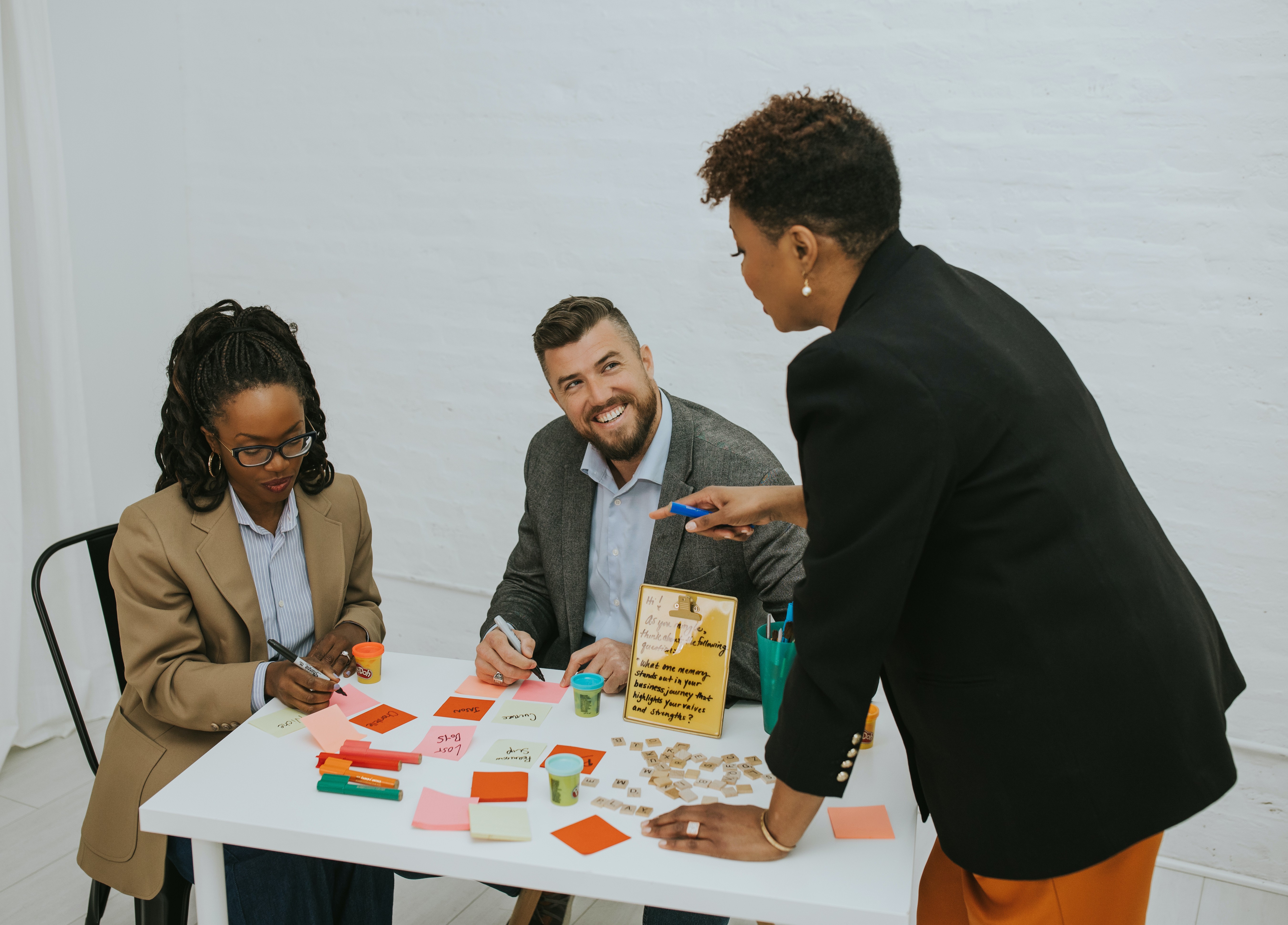 Sherita Harkness facilitating a PowerPlay™ Workshop with two leaders, all laughing and engaged. Demonstrating the psychological safety and shared joy that makes thinking visible.
