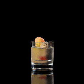 A closeup of a Peach Vodka Old Fashioned drink against a dark background.