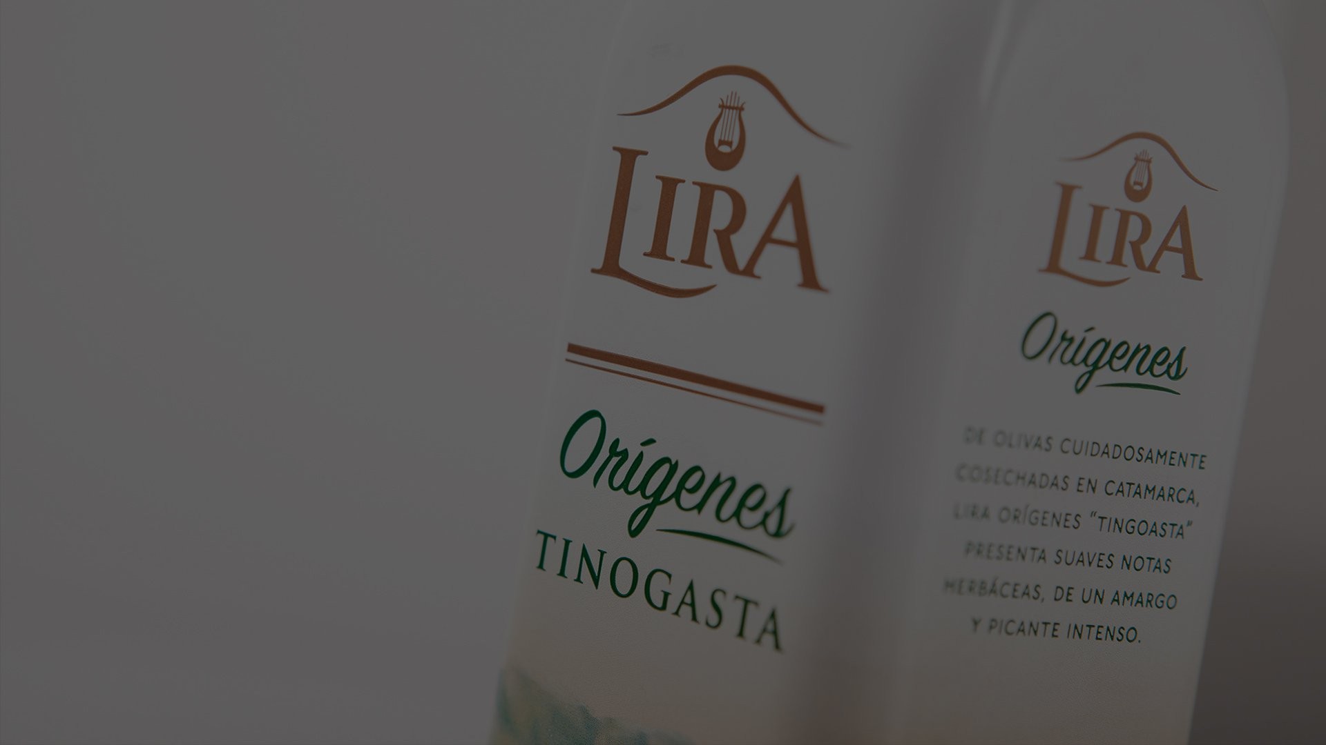 Close-up of a "Lira Orígenes" olive oil bottle with elegant typography. The label highlights "Tinogasta" origins, suggesting rich, intense flavors.