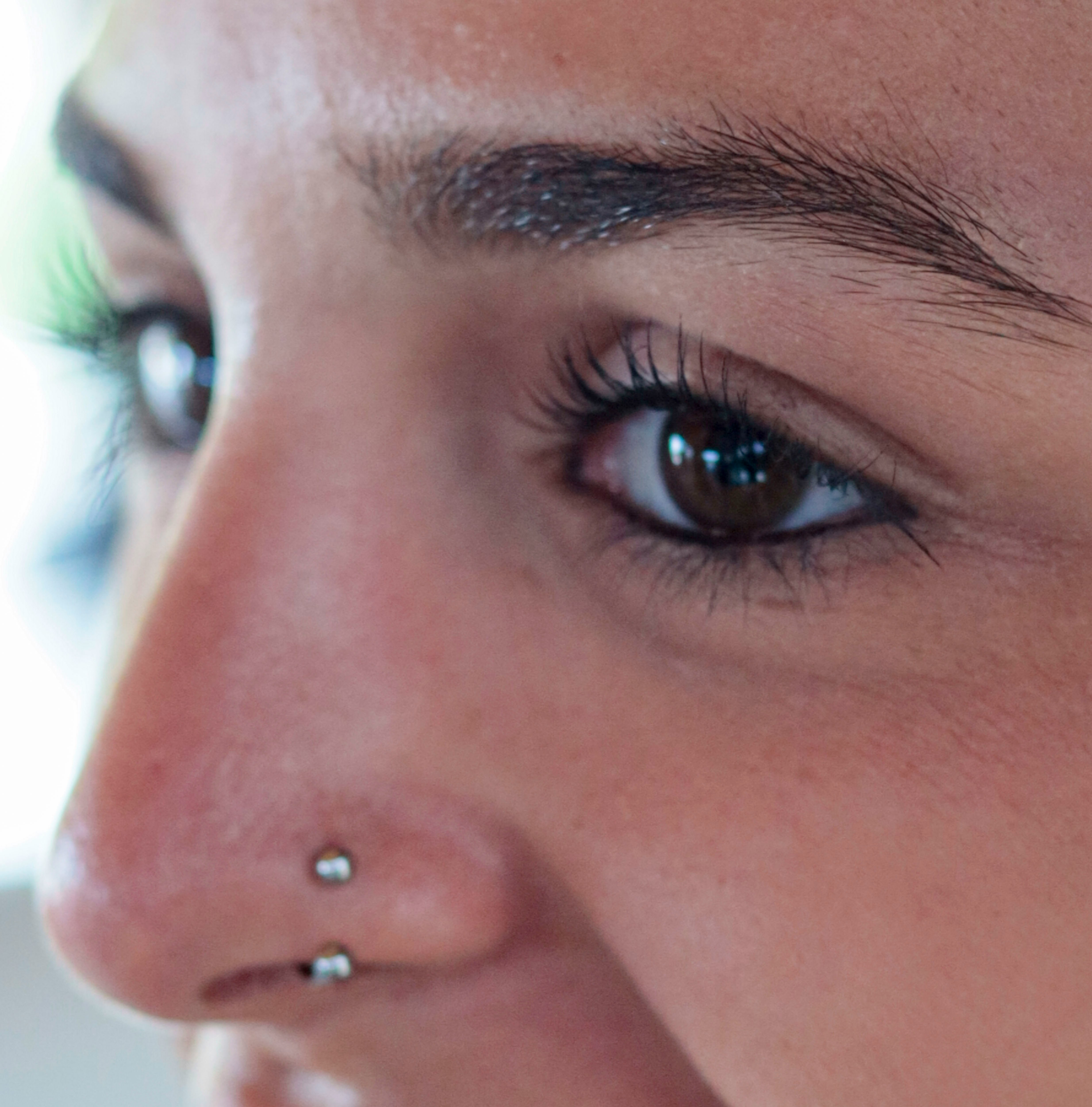 A close up of a person with a nose piercing