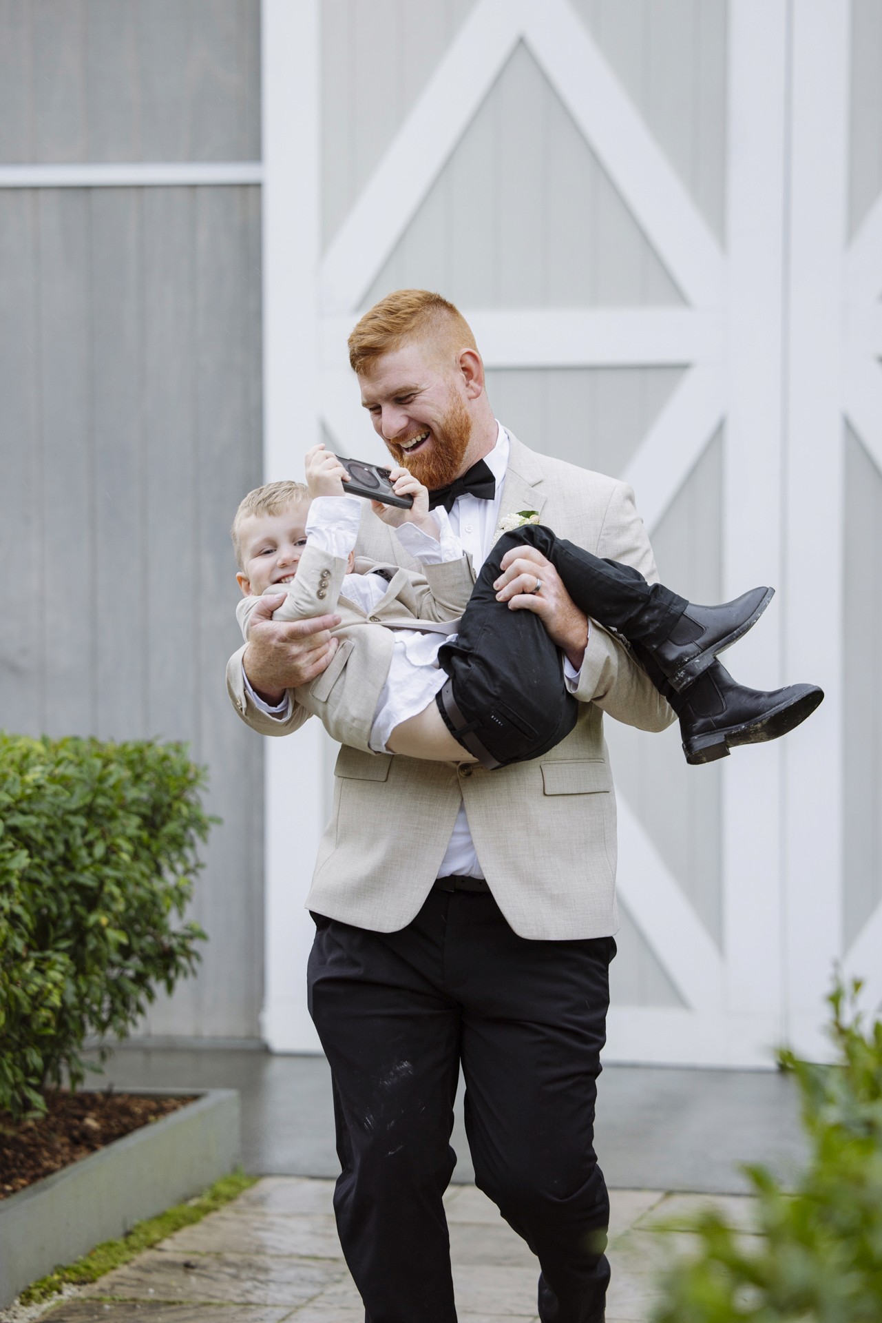 Groom carrying son down the isle