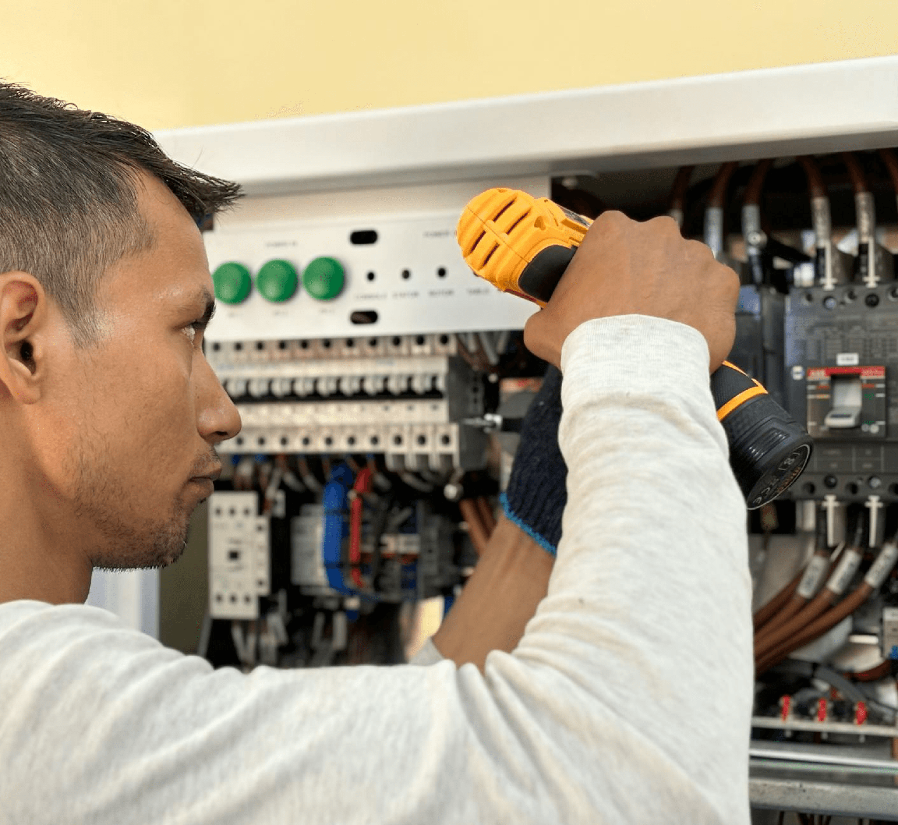 a man wearing white shirt fixing electric board