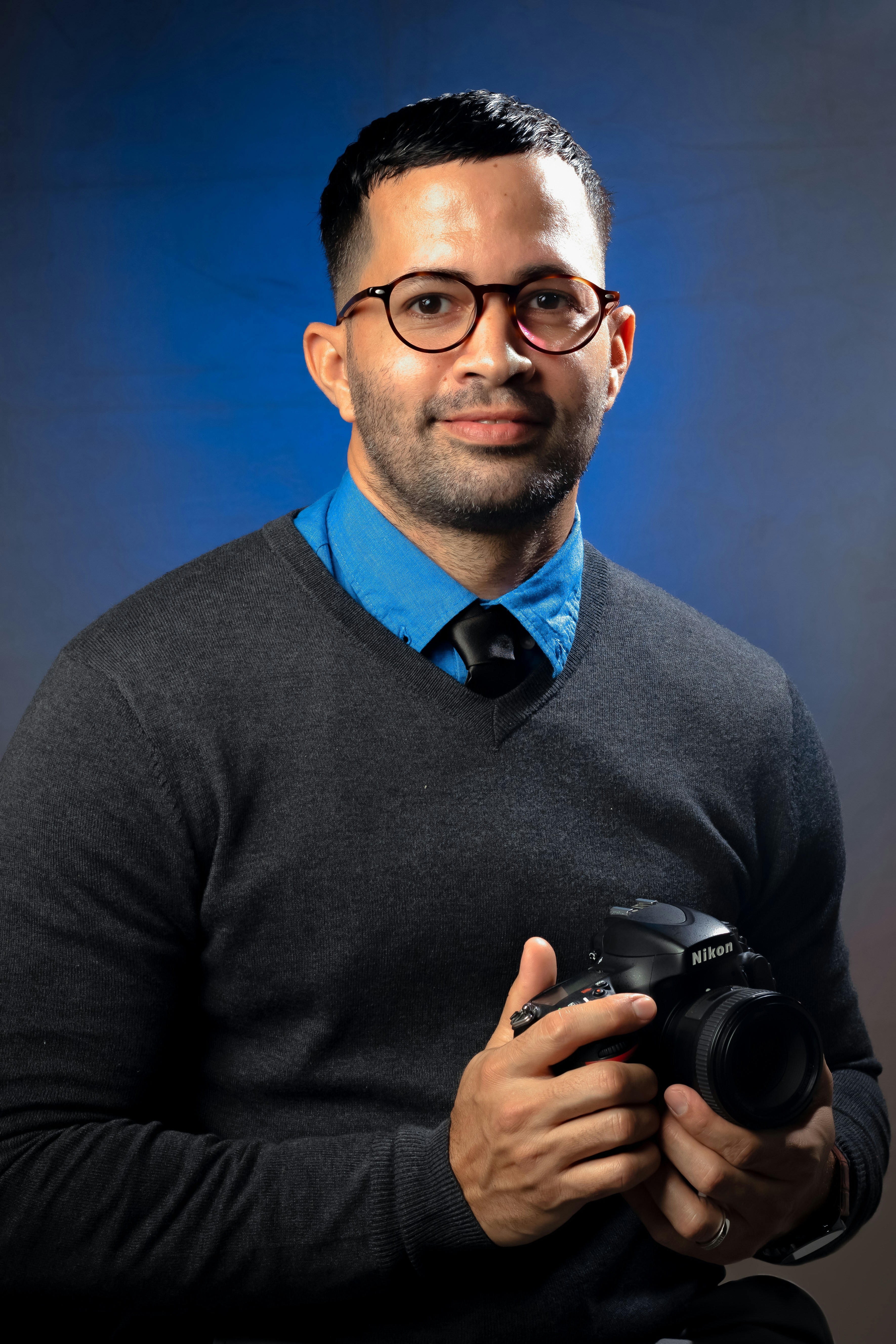 man smiling and holding bridge camera
