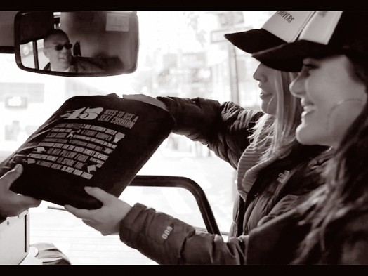 image of two girls and one has her hand in a bag offered by the bus driver