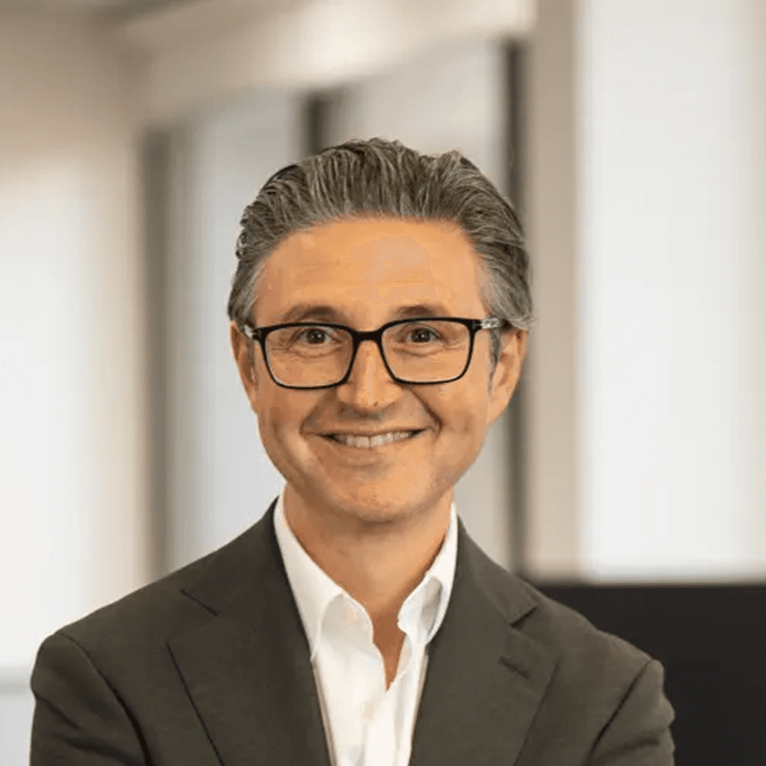 Smiling man with glasses and short dark hair.