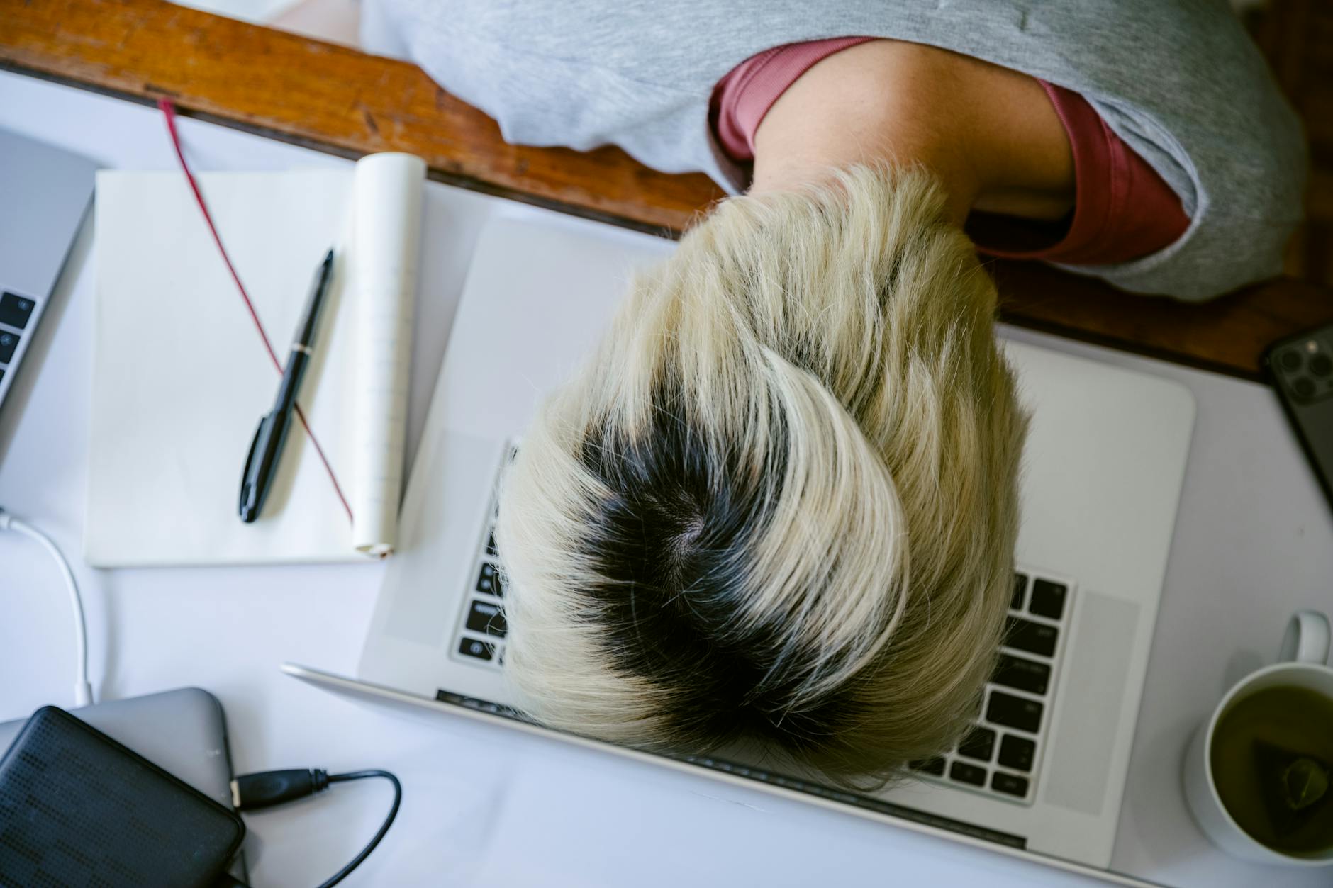 A frustrated person looking at a laptop screen showing a 404 error message while holding their head.