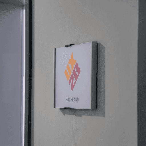 Wandtafel mit farbigem UX2B Logo und Schriftzug 'HOCHLAND' an einer hellen Wand neben einer Tür