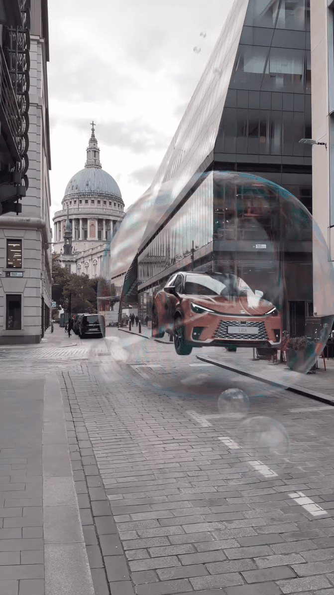 A Lexus car floats inside a giant iridescent soap bubble on a cobblestone street near a cathedral
