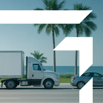 A highway with a large truck driving under a clear blue sky representing Primary Auto Liability services. A stylized letter "G" is present in the foreground.