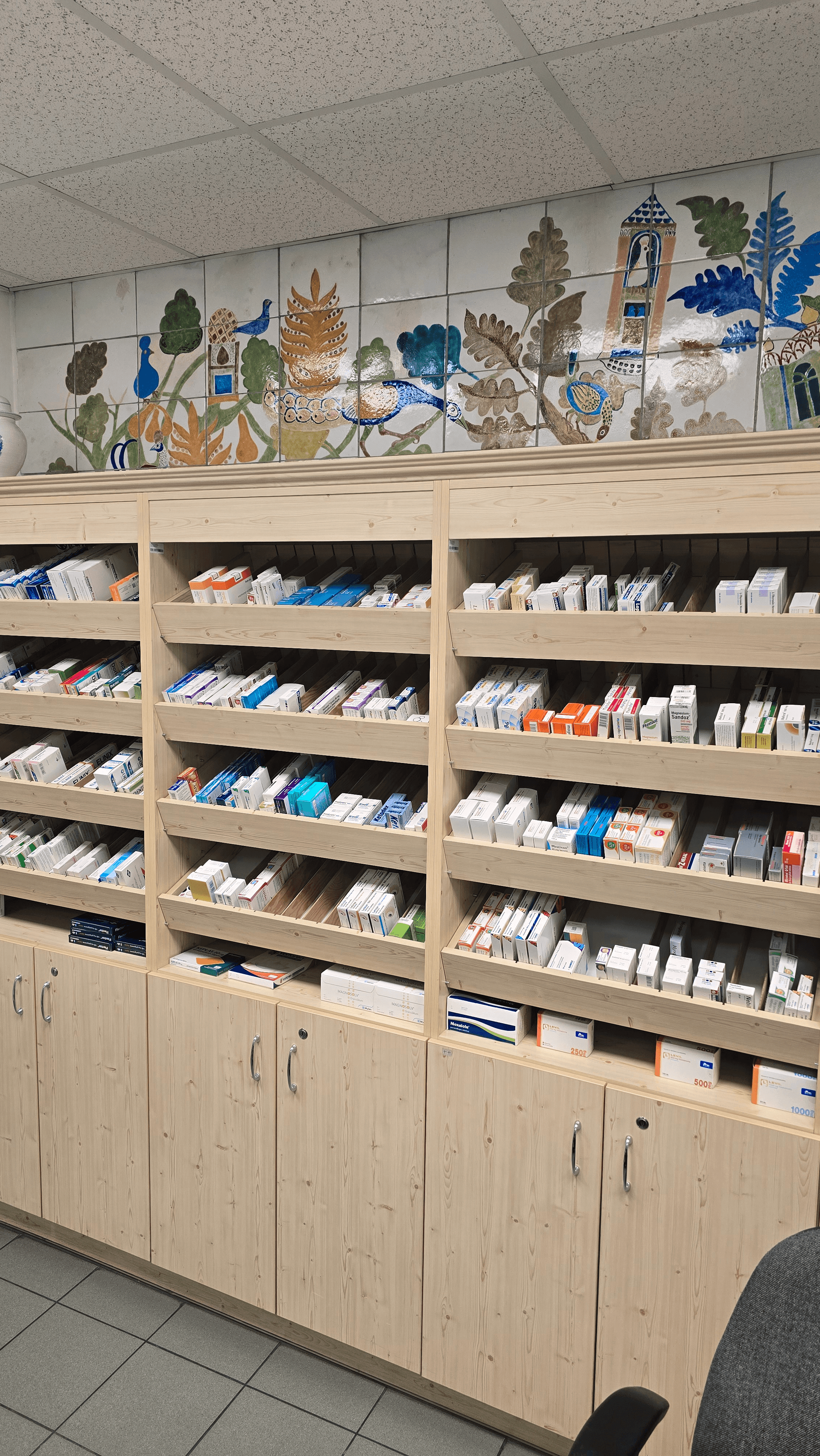 Gyógyszertári szekrények, polcokon gyógyszerekkel.