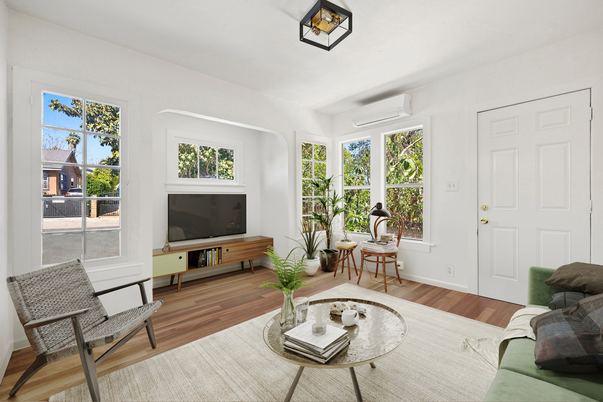 Bright and airy living room at 3456 plata, with stylish furniture, a television, and large windows letting in natural light.