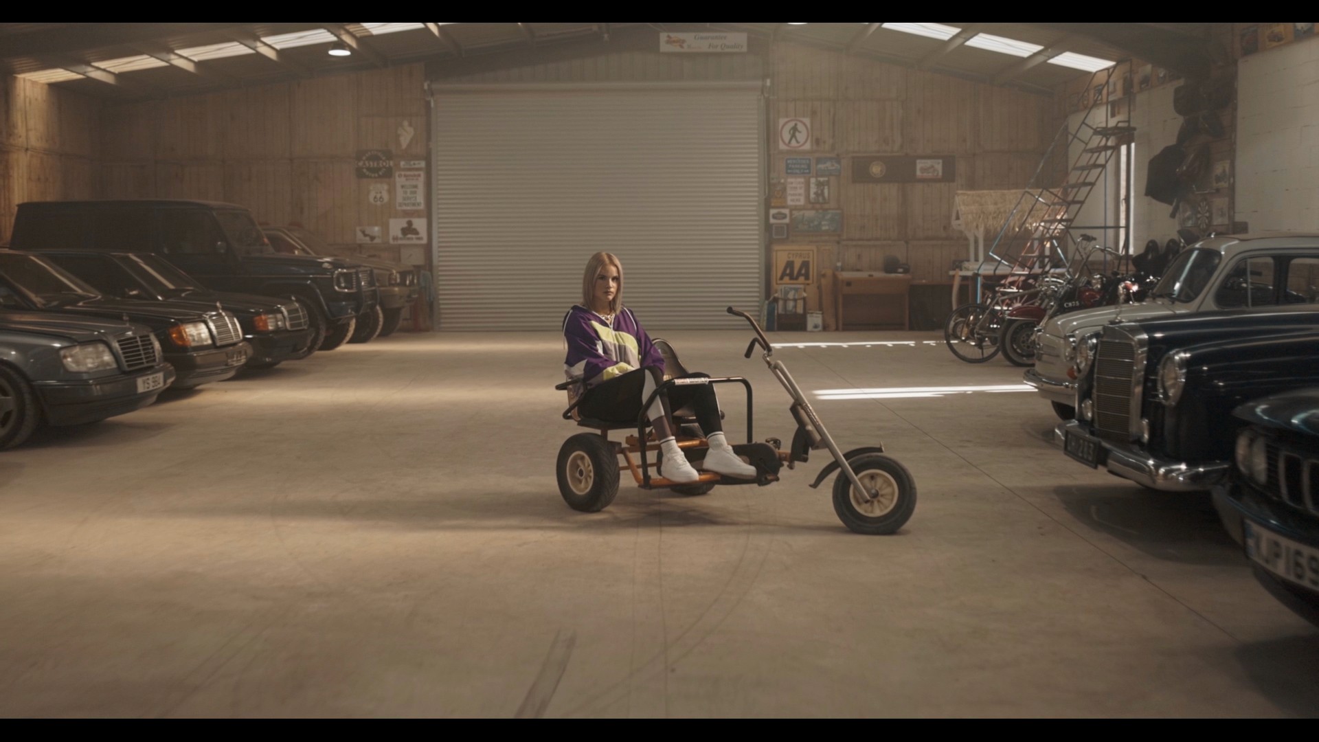 A girl is sitting on a motorbike for the needs of a music video that we shooted in a surealistic parking spot near Paralimni