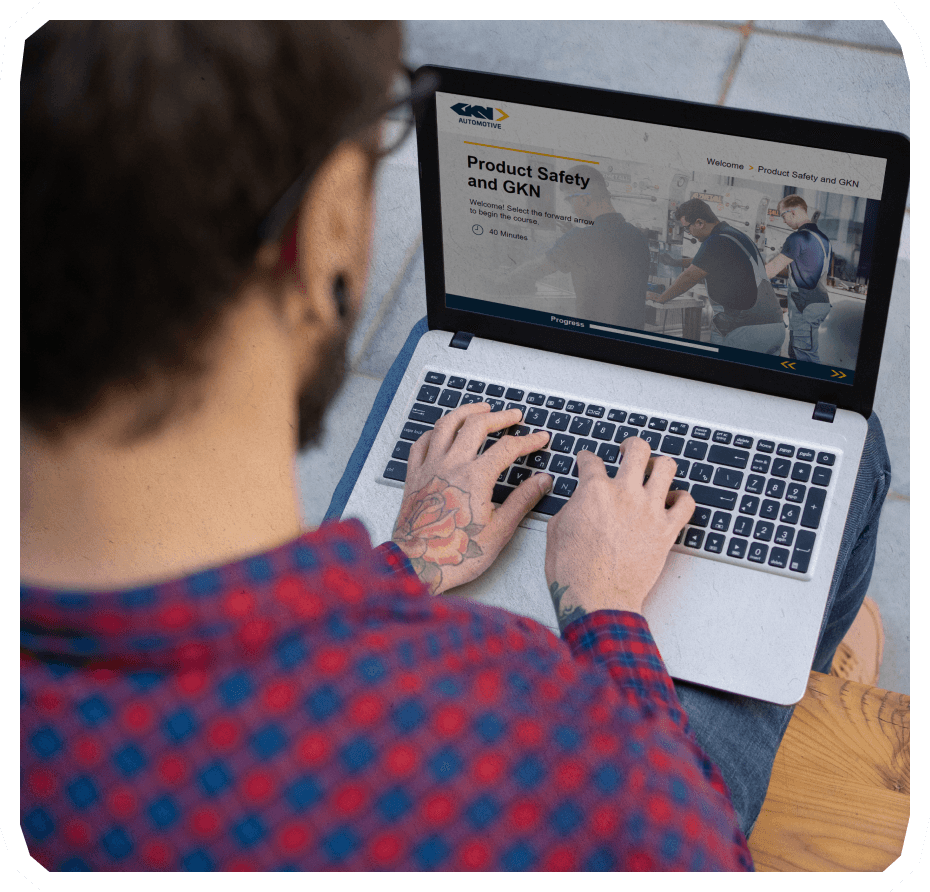 Male on his desk doing a bespoke e learning on his laptop