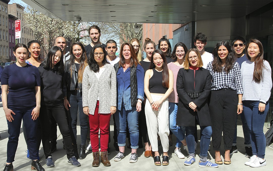 group photo of students and alumni on the sidewalk